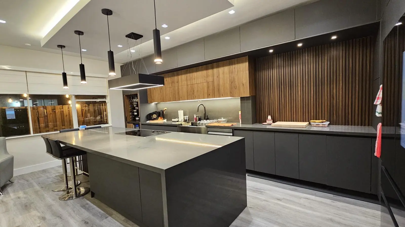 Contemporary walnut and charcoal kitchen with integrated lighting