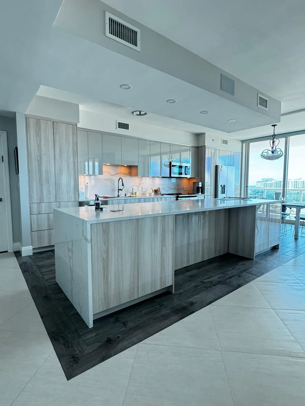 Modern gray kitchen cabinetry with island by Decoart