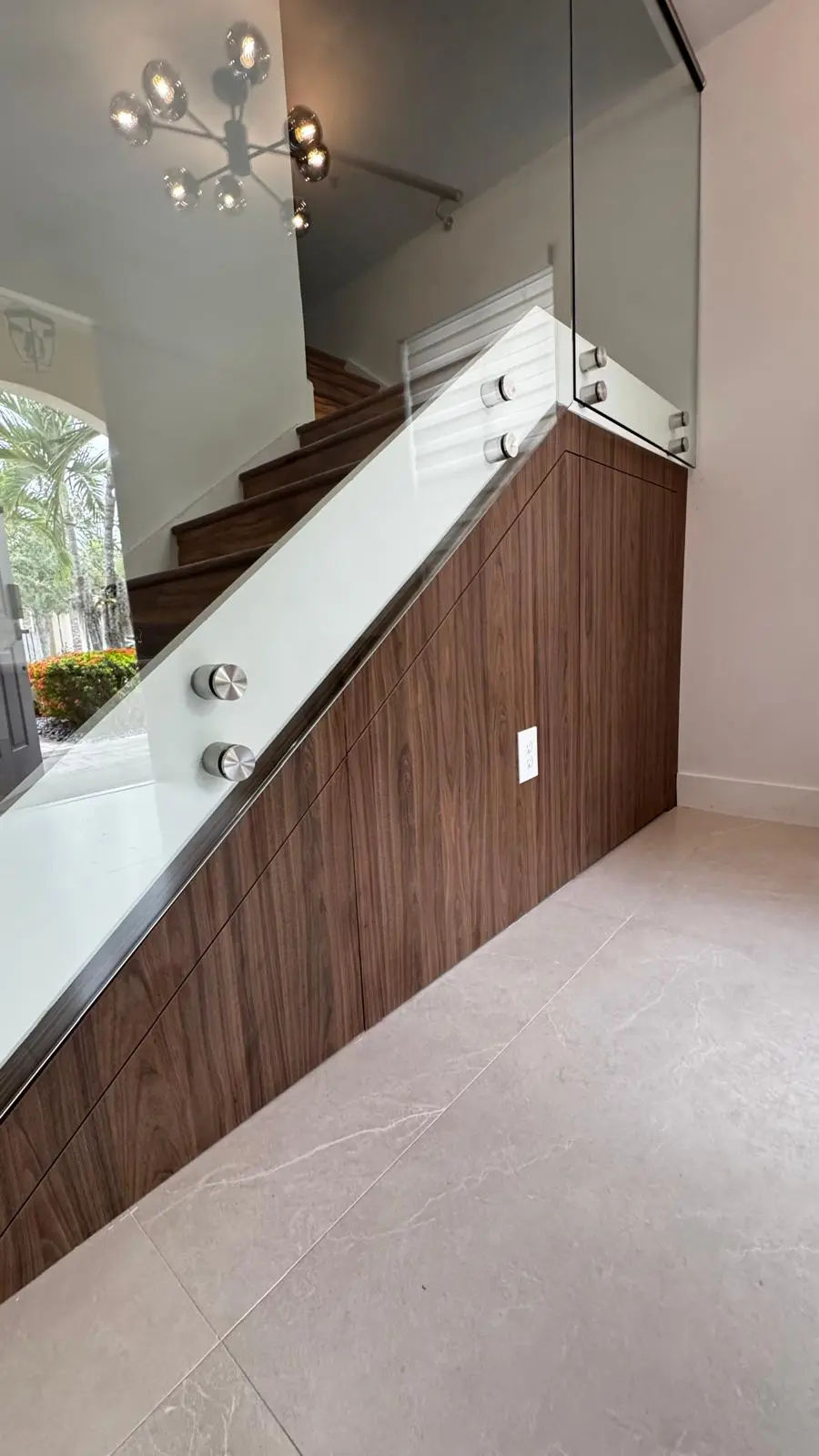 Custom walnut storage beneath a staircase by Decoart